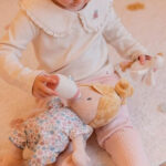 imagen de una niña dando el biberón a la Bebé Julia muñeca blandita de Little Dutch