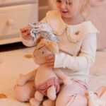 imagen de una niña vistiendo a la Bebé Julia muñeca blandita de Little Dutch