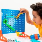 imagen de un niño creando un laberinto con el Juego de construcción circuito de canicas con taladro y tornillos