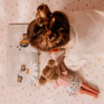 imagen de una niña leyendo con la Muñeca blandita Rosa 35cm de Little Dutch