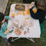 imagen de dos niñas alrededor de una mesa con el set Grapat 18 setas de madera para juego simbólico