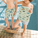 imagen de un niño con la Tabla de natación azul tiburones de Liewood