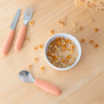 imagen del Set de cubiertos Kiddikutter Naranja con un bol de cereales