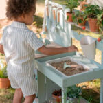 imagen de un niño jugando con la Cocinita de madera para exterior de Little Dutch