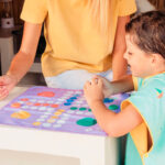 imagen de un grupo de niños jugando con el Juego de playa 2 en 1 Parchís y Tres en Raya de Quut