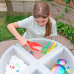 imagen de una niña jugando en una mesa de experimentación con el Set de 3 palas translucidas de colores de Tickit