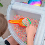 imagen de una niña haciendo trasvases con el Set de 3 palas translucidas de colores de Tickit