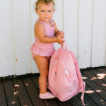 imagen de una niña con la Mochila infantil antiarena Ballena Rosa de Monnëka