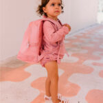 imagen de una niña con la Mochila infantil antiarena Ballena Rosa de Monnëka puesta