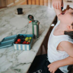 imagen de un niño con la Caja de almuerzo con 3 bandejas extraíbles azul Noui Noui
